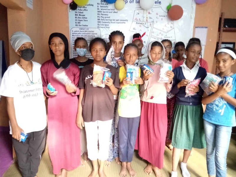 Un groupe de filles et de jeunes femmes posent ensemble lors d'une activité.