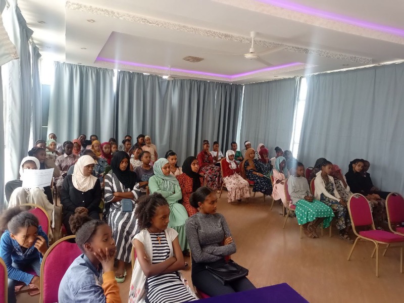 Une salle remplie de participantes et de participants assis pendant une session.