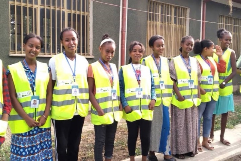 Une rangée de jeunes femmes en gilets jaunes.